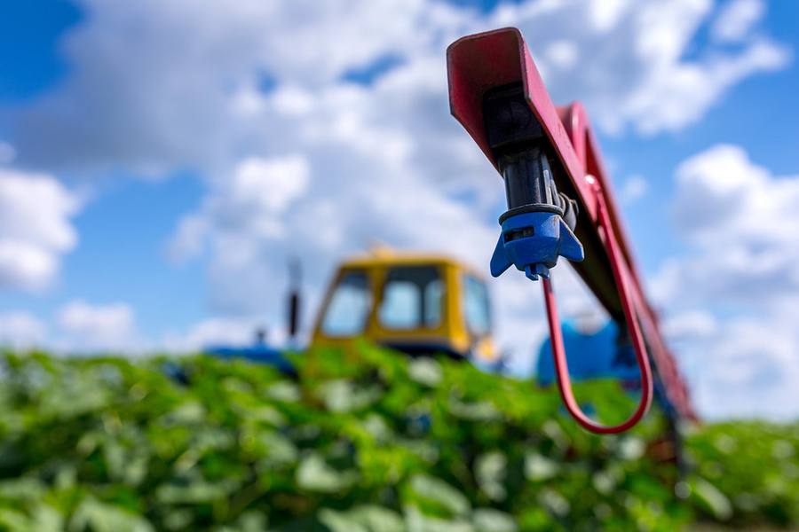 Precision sprayer boom over a green field