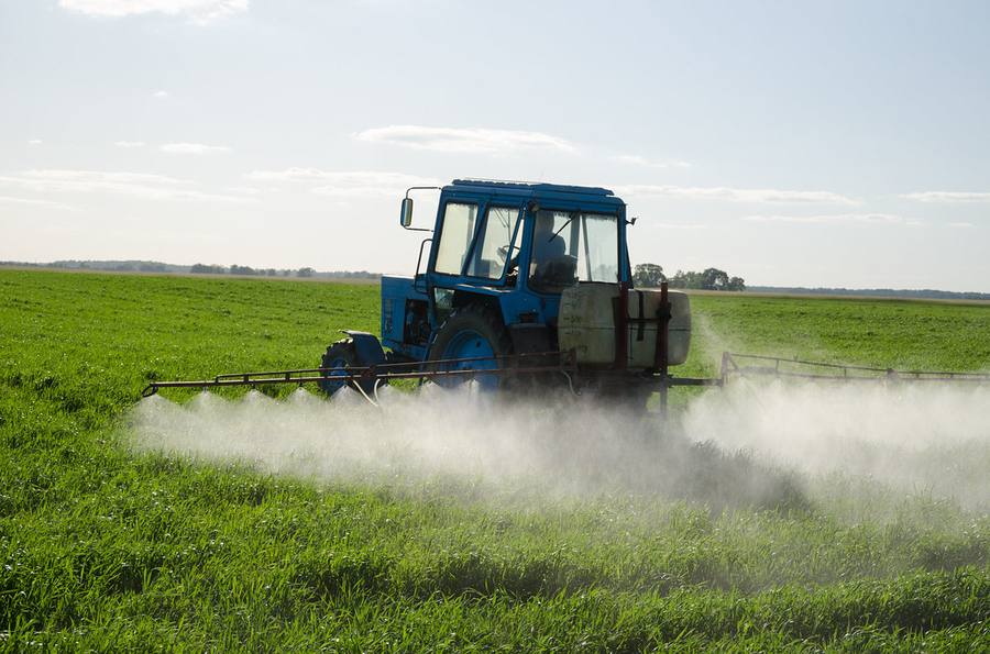 Tractor with a precision sprayer working a green field